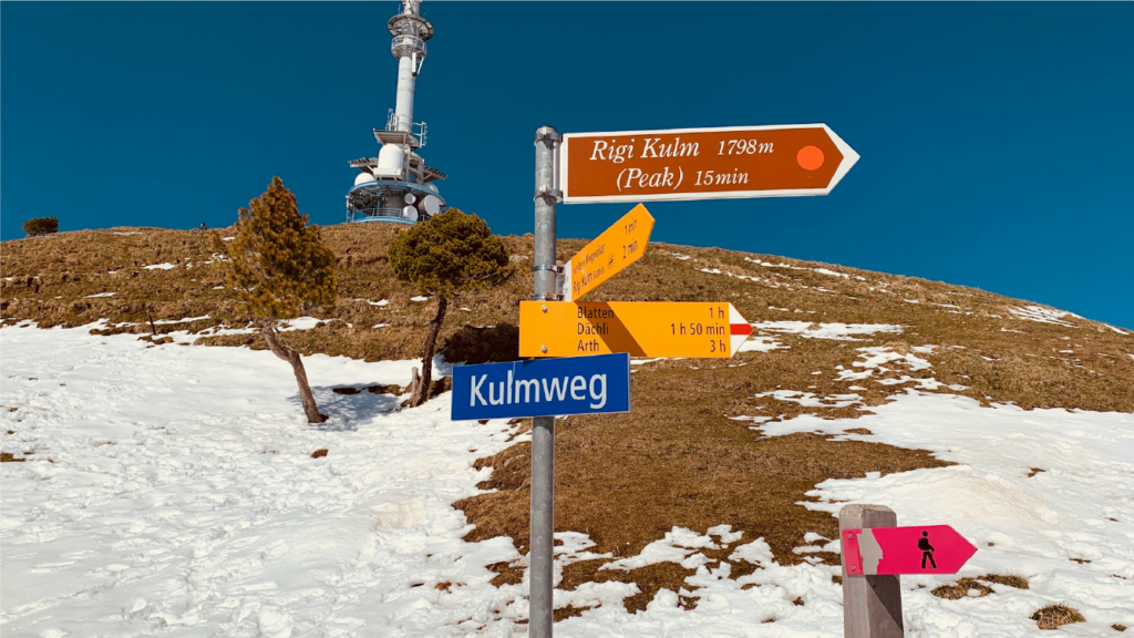 Hiking trail signposts with time-to-destination indicators on Mount Rigi, Switzerland, in winter