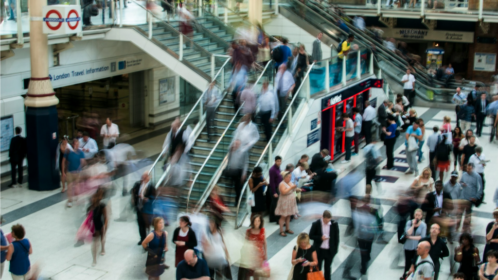Blurred crowd at a London train station, symbolizing UK ETA's impact on travel flow.